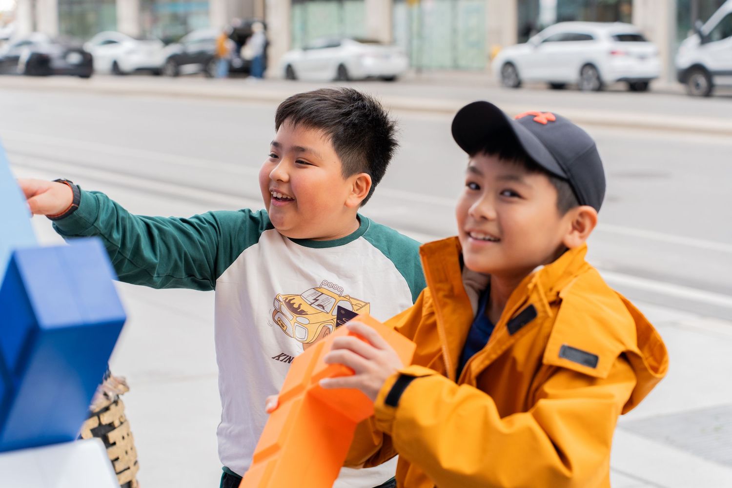 Two young boys excitedly holding blue shopping bags at a BMO event.