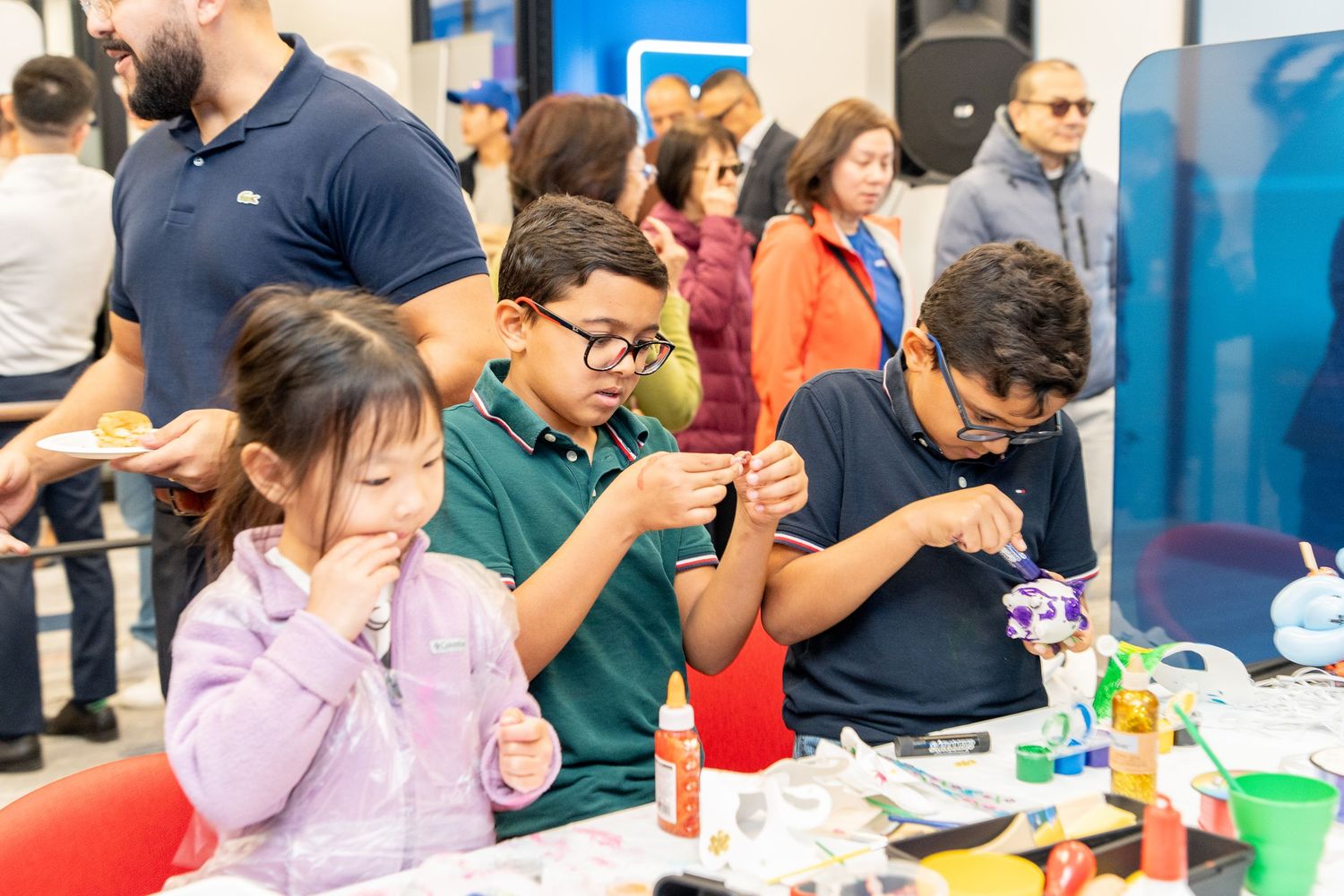 Children doing crafts at a BMO family community event indoors.
