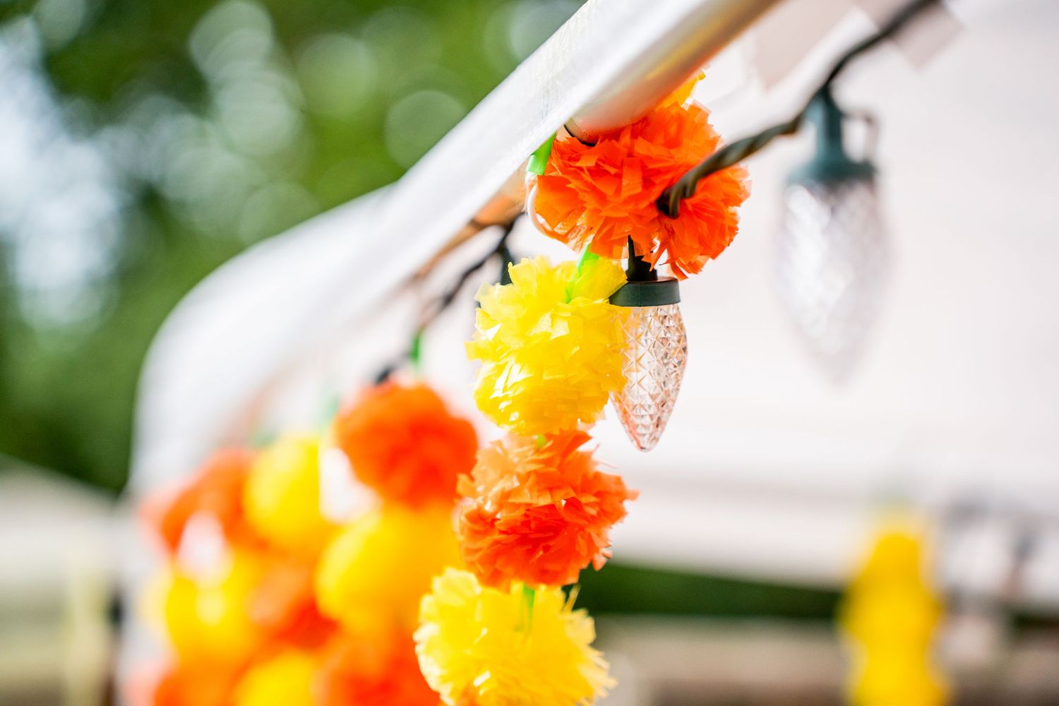 Vibrant orange and yellow marigold flower garland decorations at an outdoor Indian wedding.