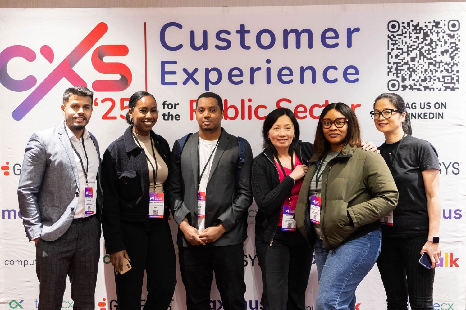 Group of six diverse professionals posing at CXS 2025 Customer Experience for the Public Sector conference.