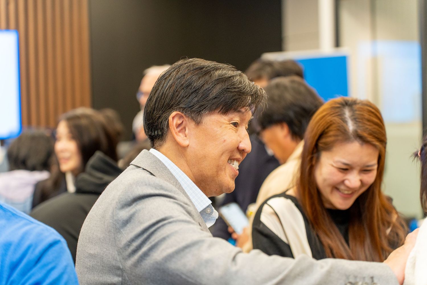 Diverse group of smiling professionals networking at a BMO corporate event.