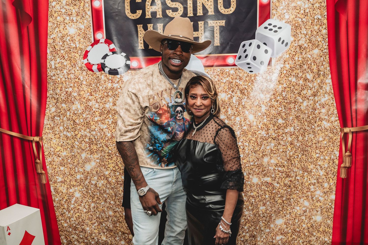 Casino party backdrop with gold glitter and red curtains frames entertainment and decor.