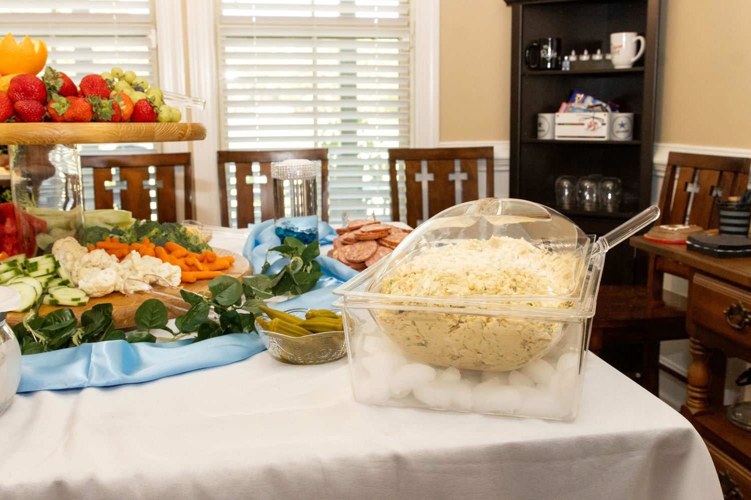 Catering table spread with various dishes and food items at an indoor event.