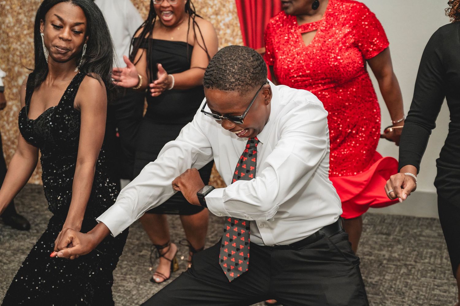 People dancing and enjoying themselves at a lively party with formal attire.
