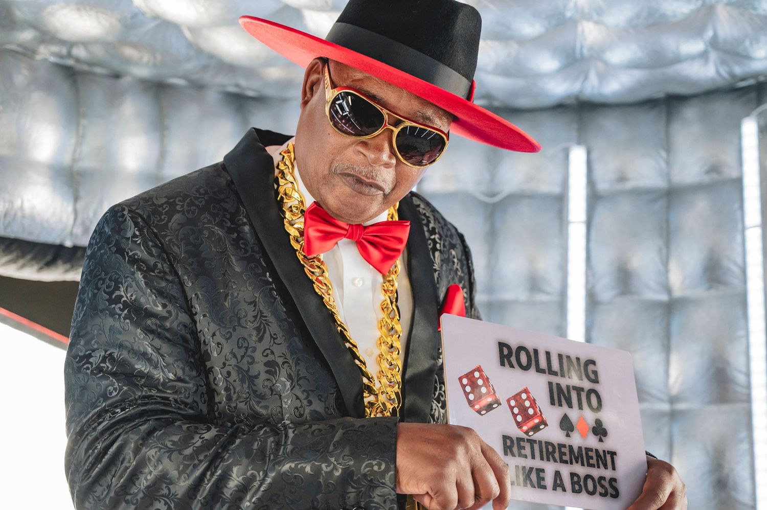 Performer in red and black attire entertaining crowd at casino themed party.
