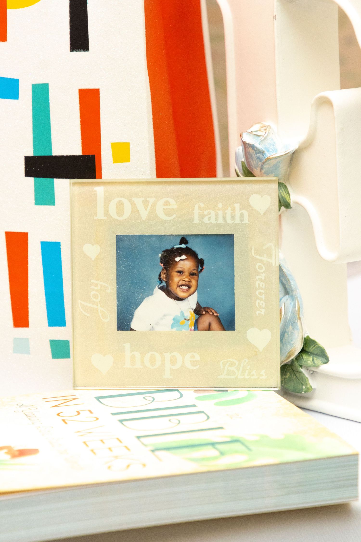 Colorful modern photo wall display with decorative text elements and photos arranged on white ledges.