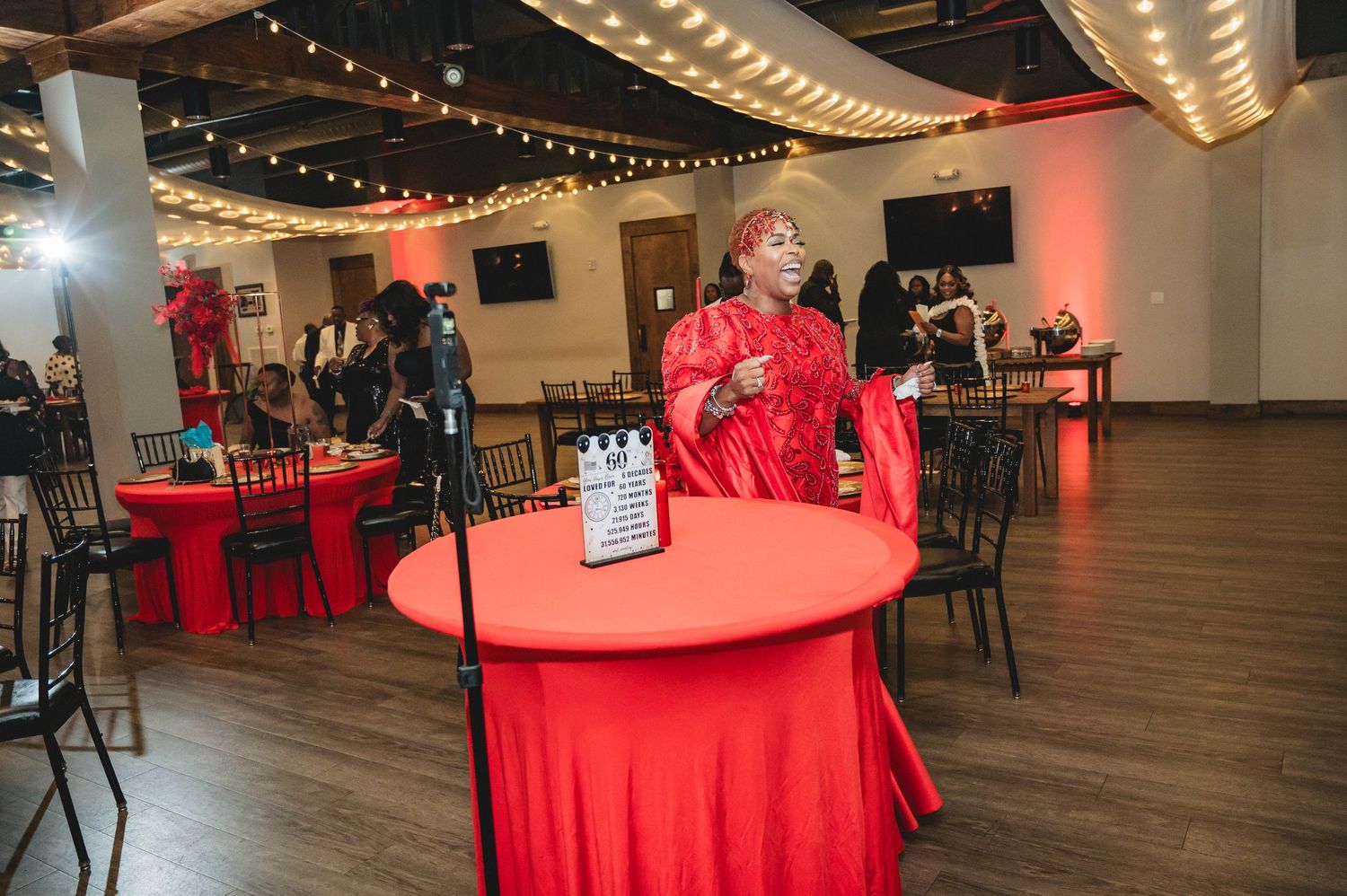Spacious venue hall with warm lighting and brick walls decorated for an elegant evening celebration.