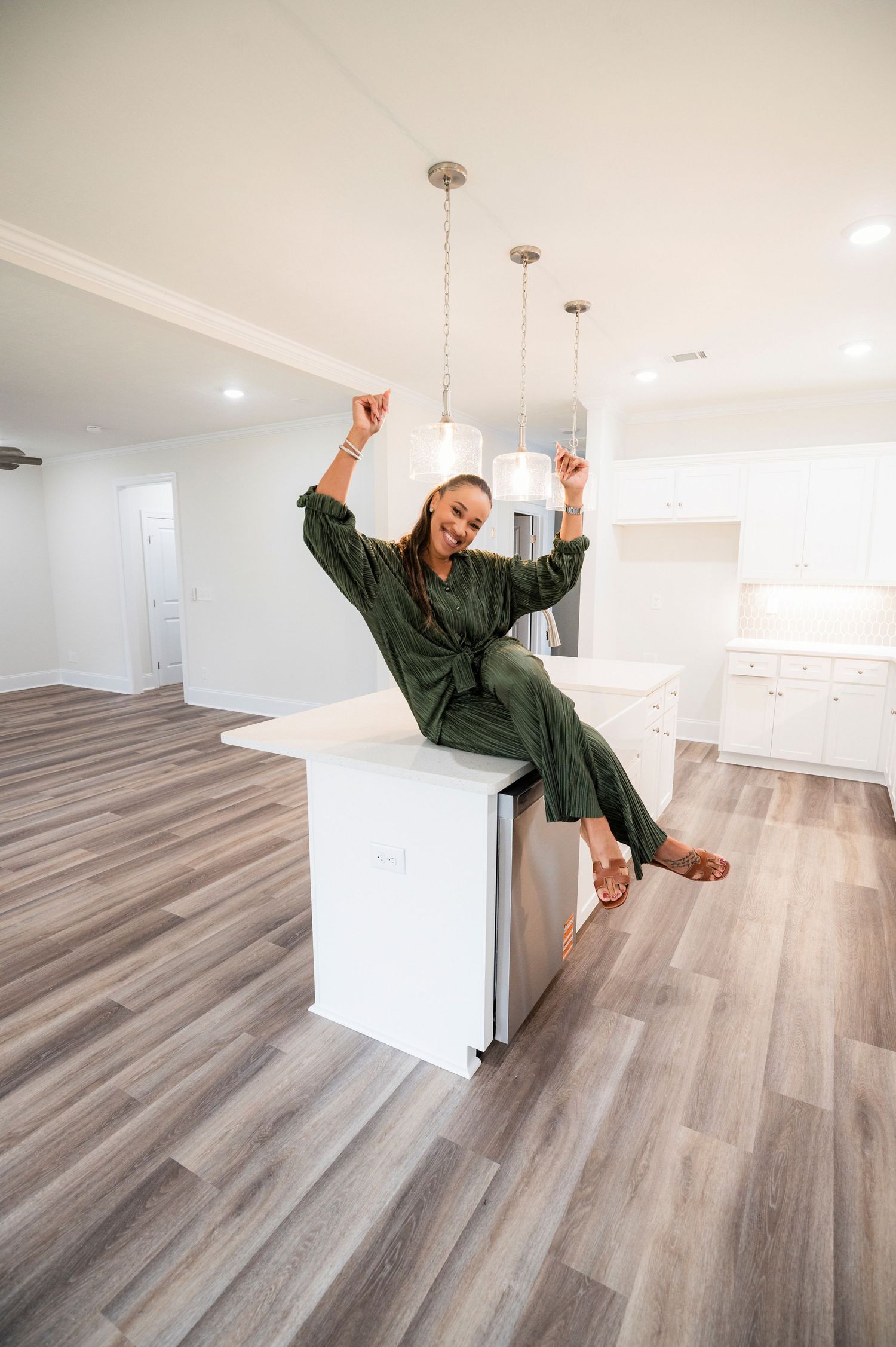 A sequence of photos showing someone in a green robe jumping and dancing excitedly in an empty room with wood floors.