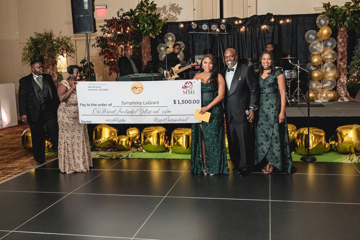 Guests in formal attire gather at an elegant indoor event venue with decorative lighting and displays.