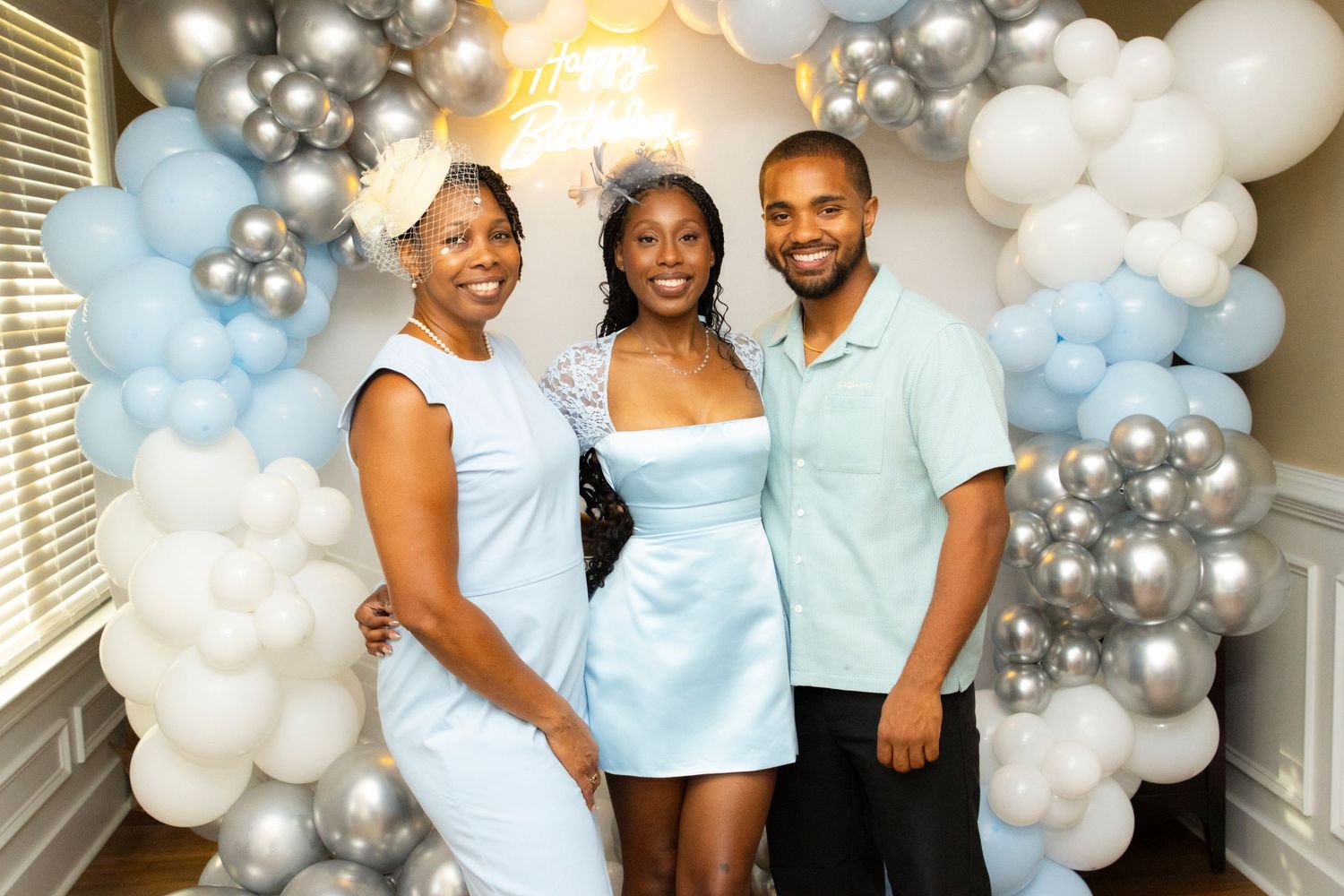 Group photo with guests wearing coordinated pastel blue outfits at a celebration.