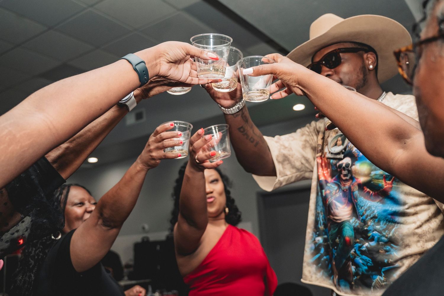 Guests raising glasses in a celebratory toast during a casino-themed party.