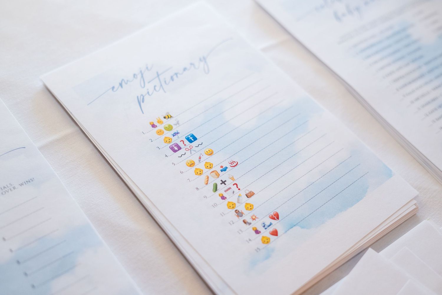 Colorful emoji stickers arranged in a vertical line on a white notebook page with blue marks.