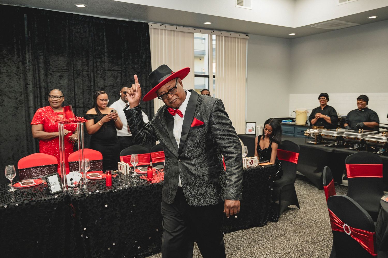 Casino night party setup with red and black decorations in an indoor event space.