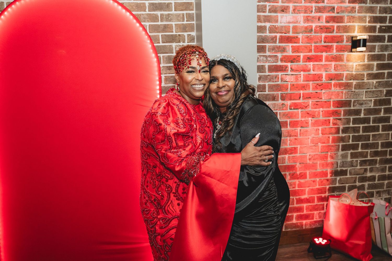 Partygoers gather in a venue decorated with red accents and ambient lighting.