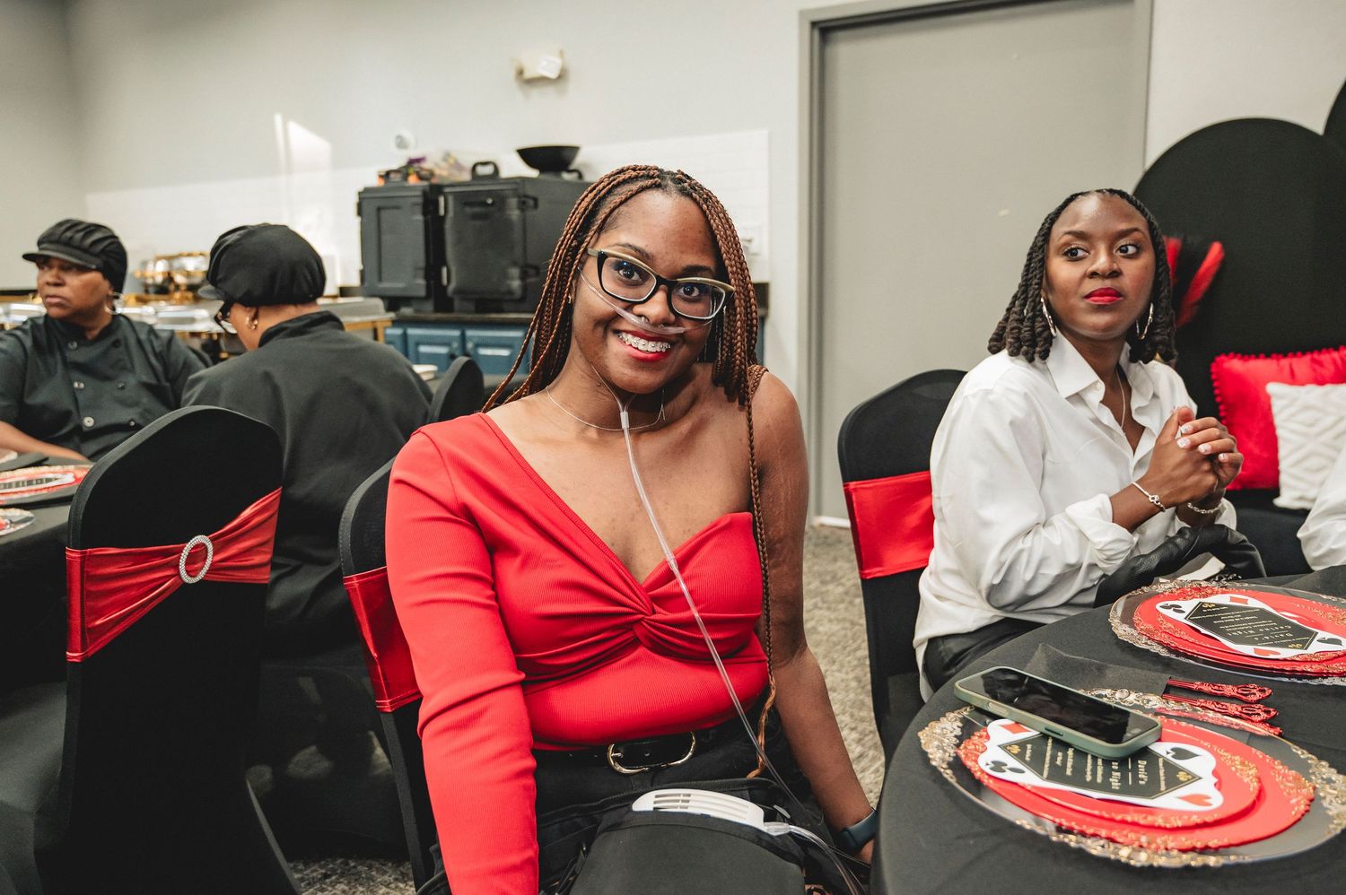 Guests enjoying a casino-themed party with red and black decor and table settings.