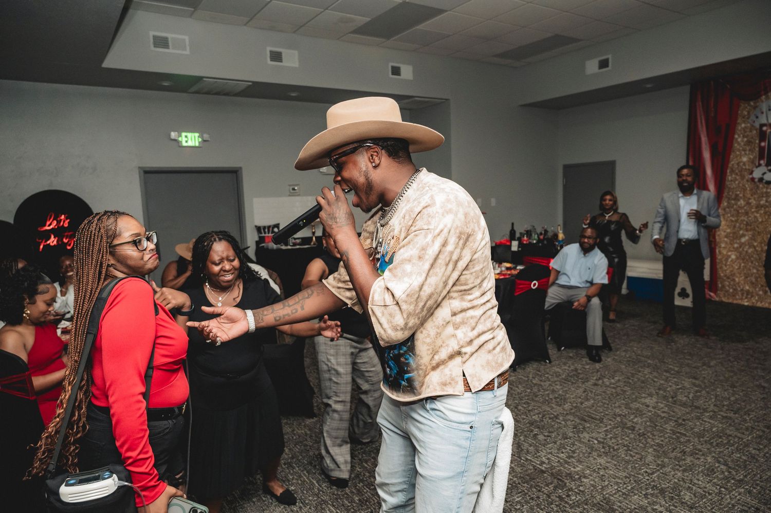 Party guests dance and celebrate in a venue decorated with casino-themed elements.