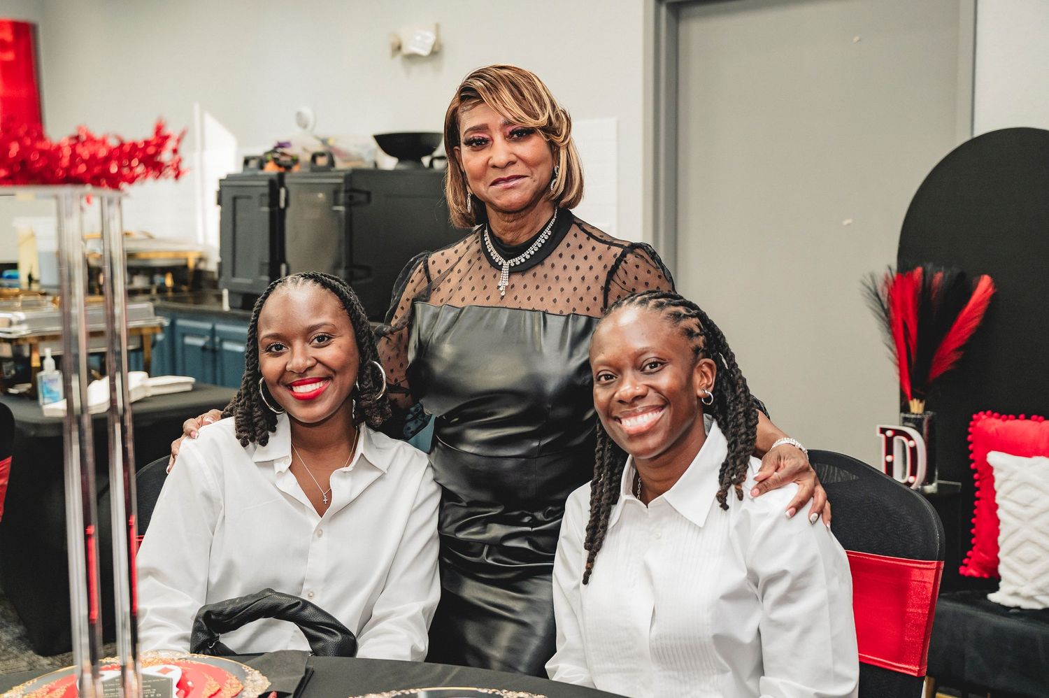 A group of people in a professional setting share joyful moments together at an indoor gathering.