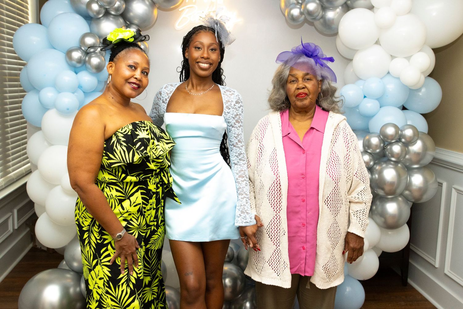 A festive baby shower celebration with blue and silver balloon decorations and guests gathering in a decorated room.