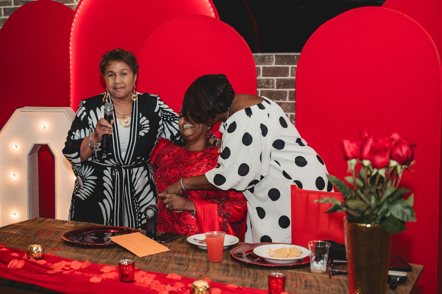 Table settings with red and polka dot decor elements creating a festive atmosphere at an event.
