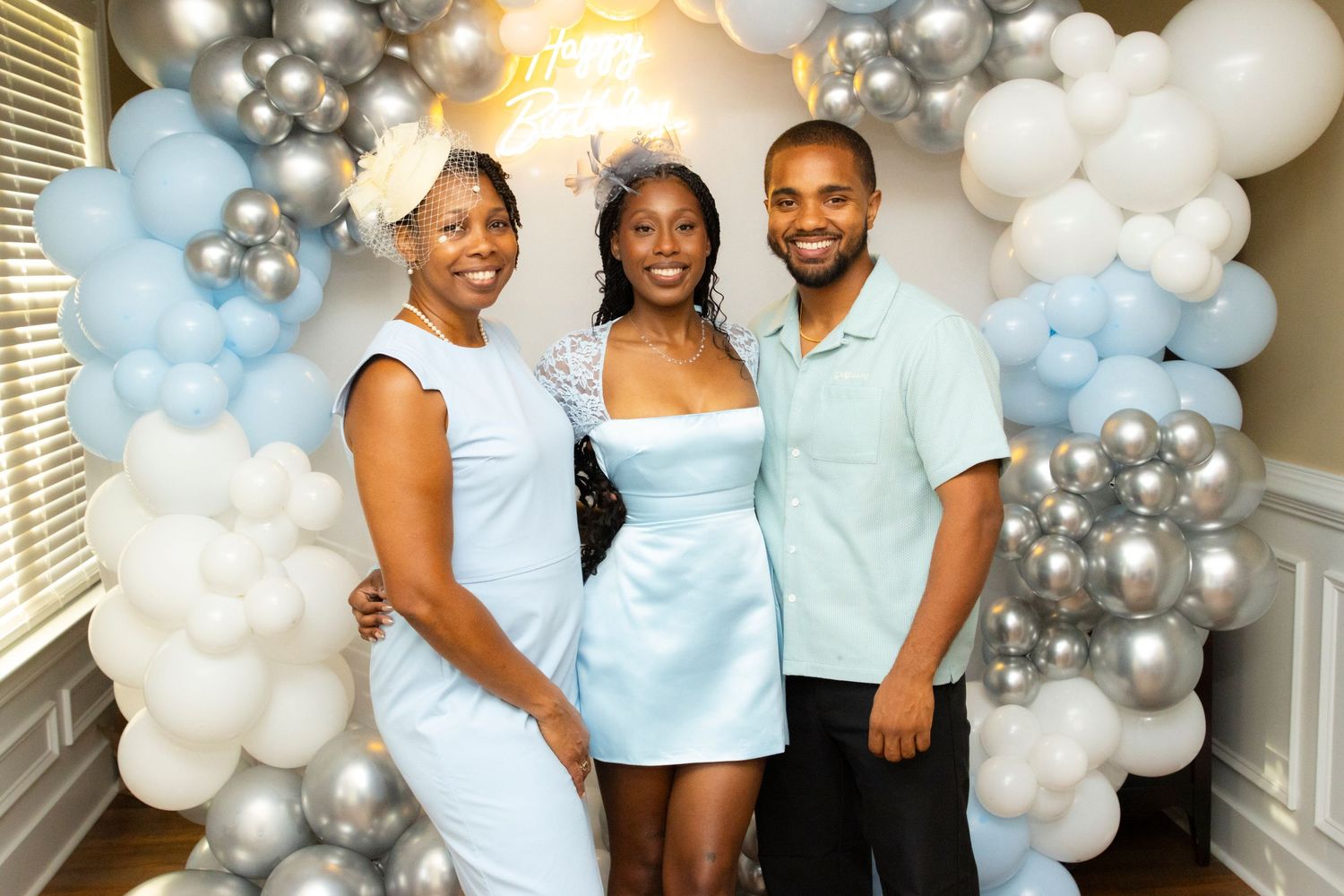 Celebration gathering with family members in matching light blue and white attire.