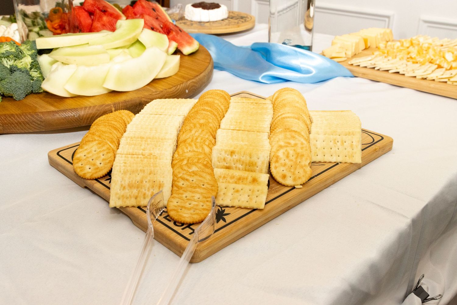 Fresh loaves of French bread displayed on a wooden serving board at a catered event.