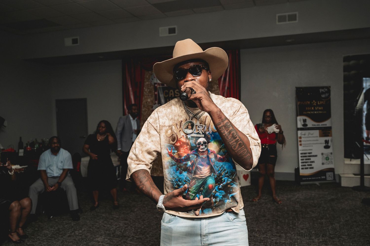 A performer in western attire entertaining guests at an indoor event.