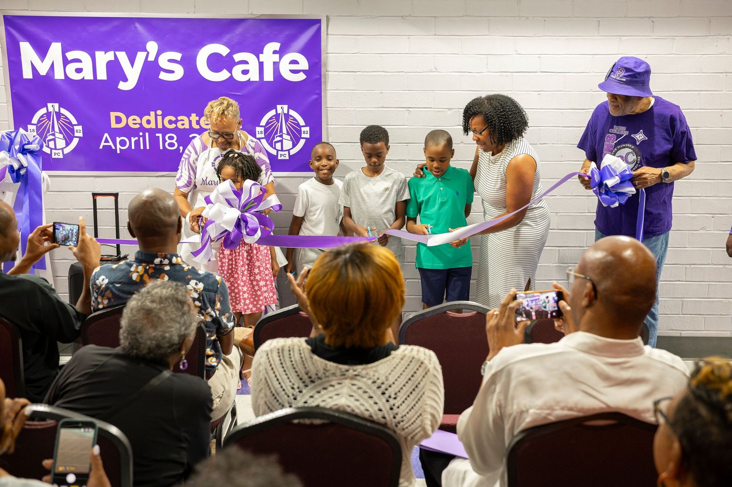Community members celebrate ribbon cutting ceremony at Mary's Cafe dedication event on April 18.