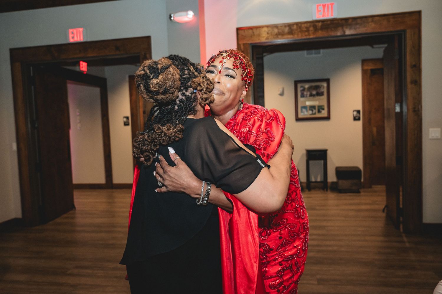 Couples dancing in an intimate venue with red lighting and wooden floors.
