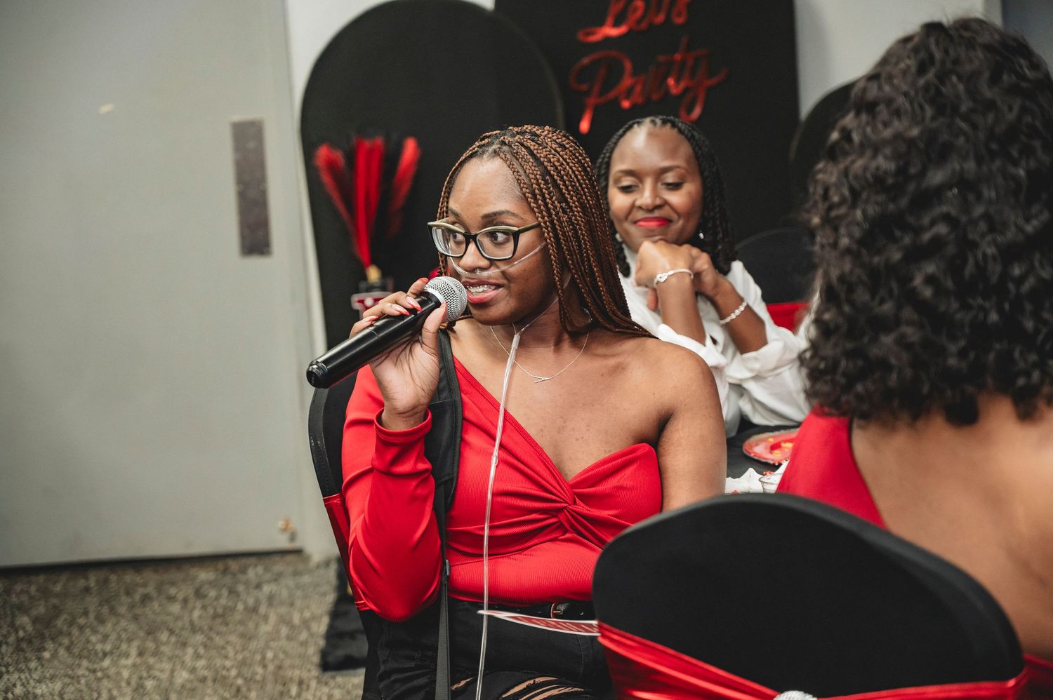 Party guests in formal attire enjoying a casino-themed celebration with red decor.