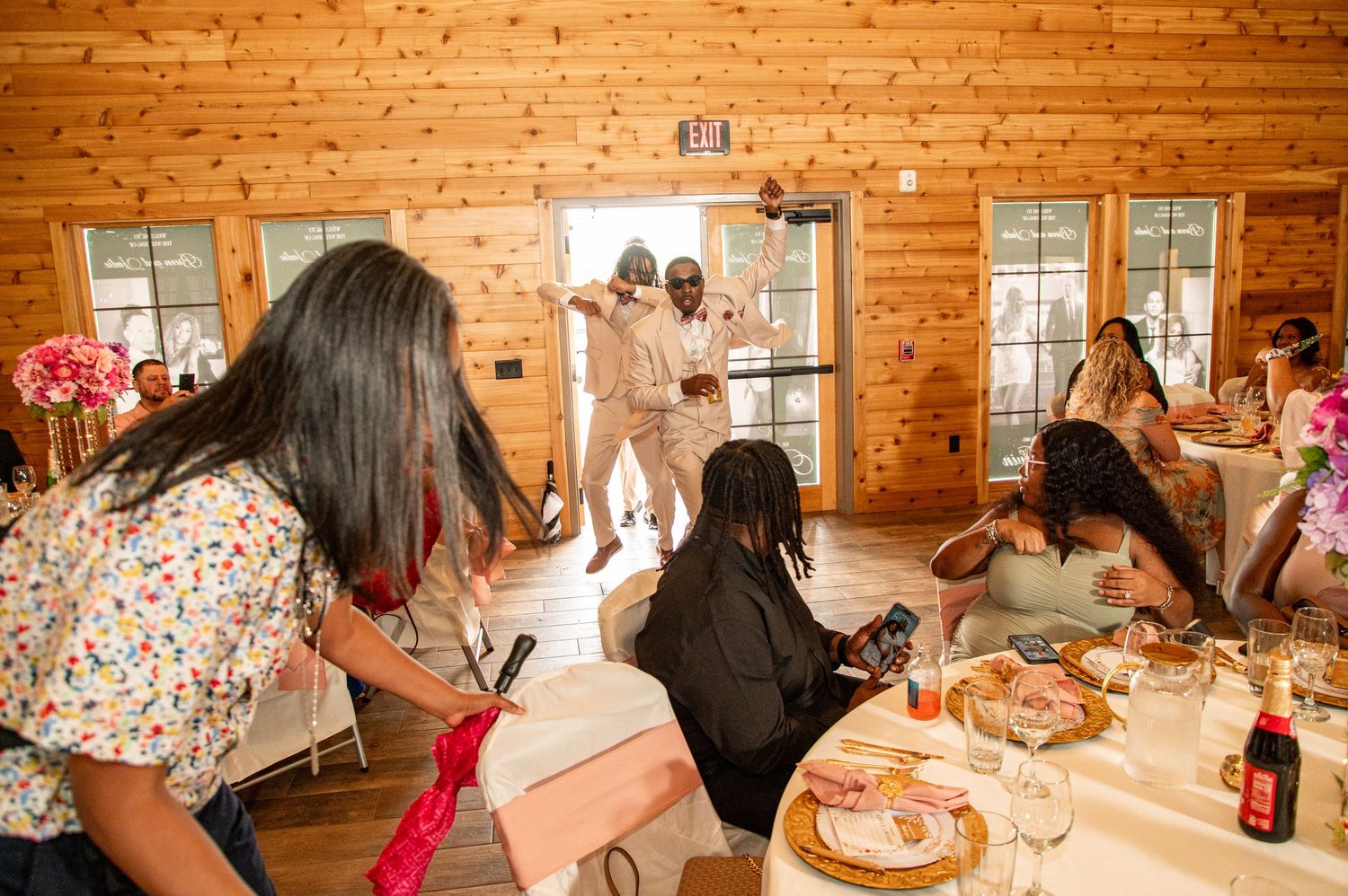 Wedding guests celebrating as couple makes grand entrance into reception hall.