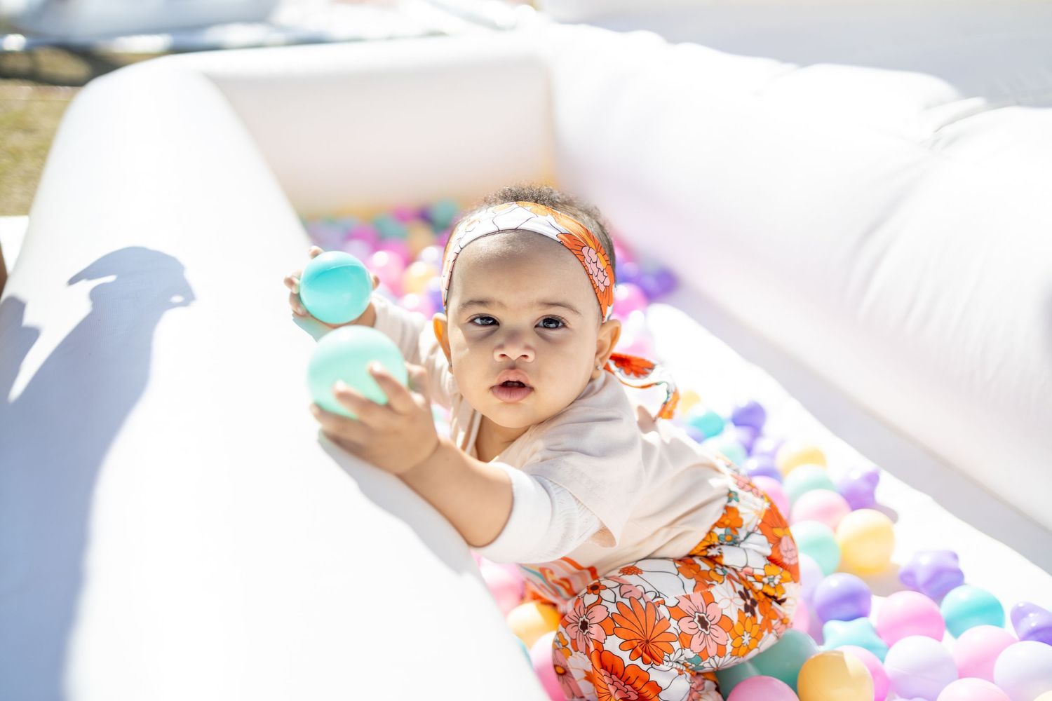 A colorful party scene with scattered balloons and festive decorations creates a cheerful celebration atmosphere.