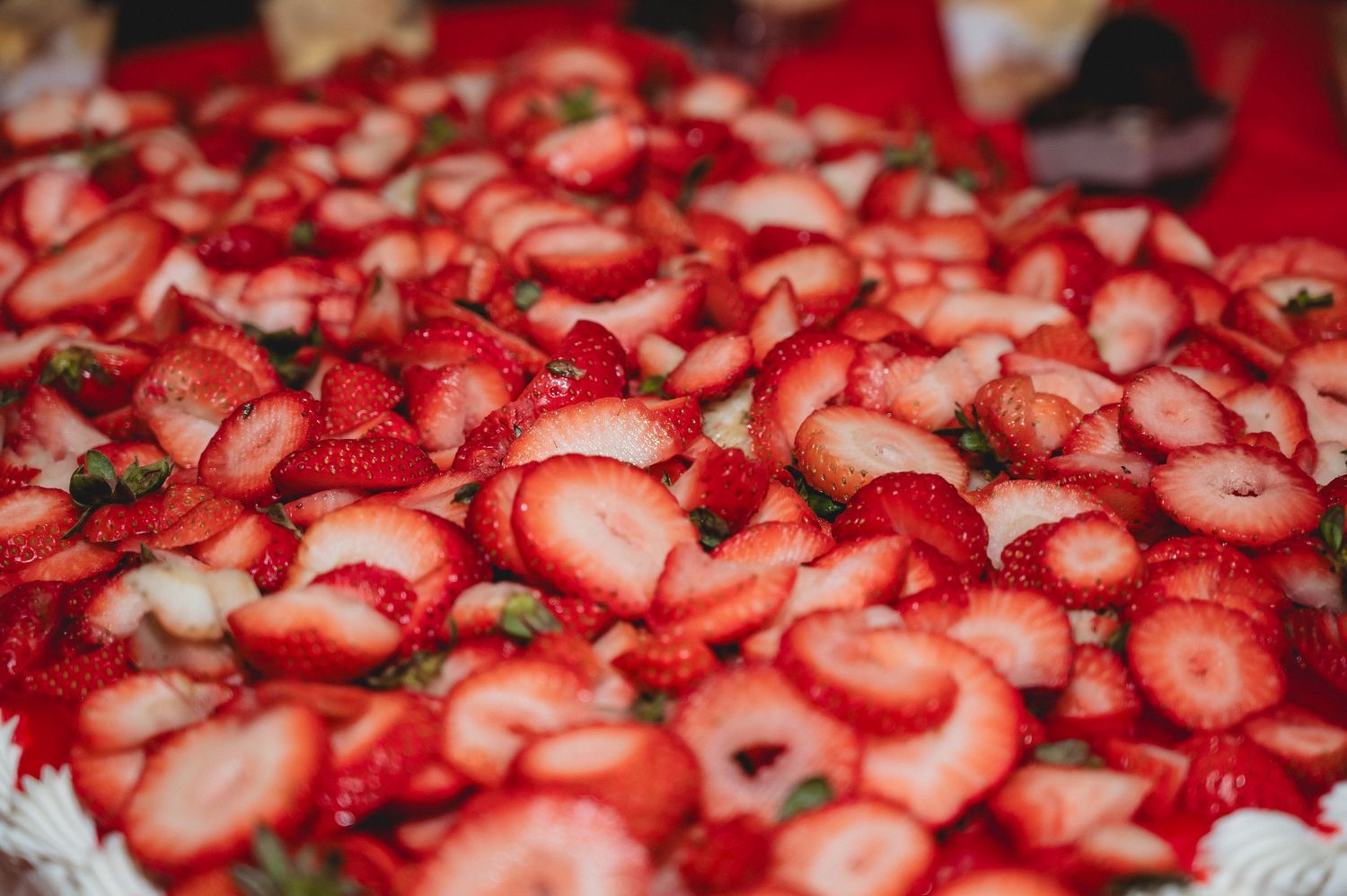Fresh sliced red strawberries create a vibrant pattern filling the entire frame with their juicy texture and bright color.