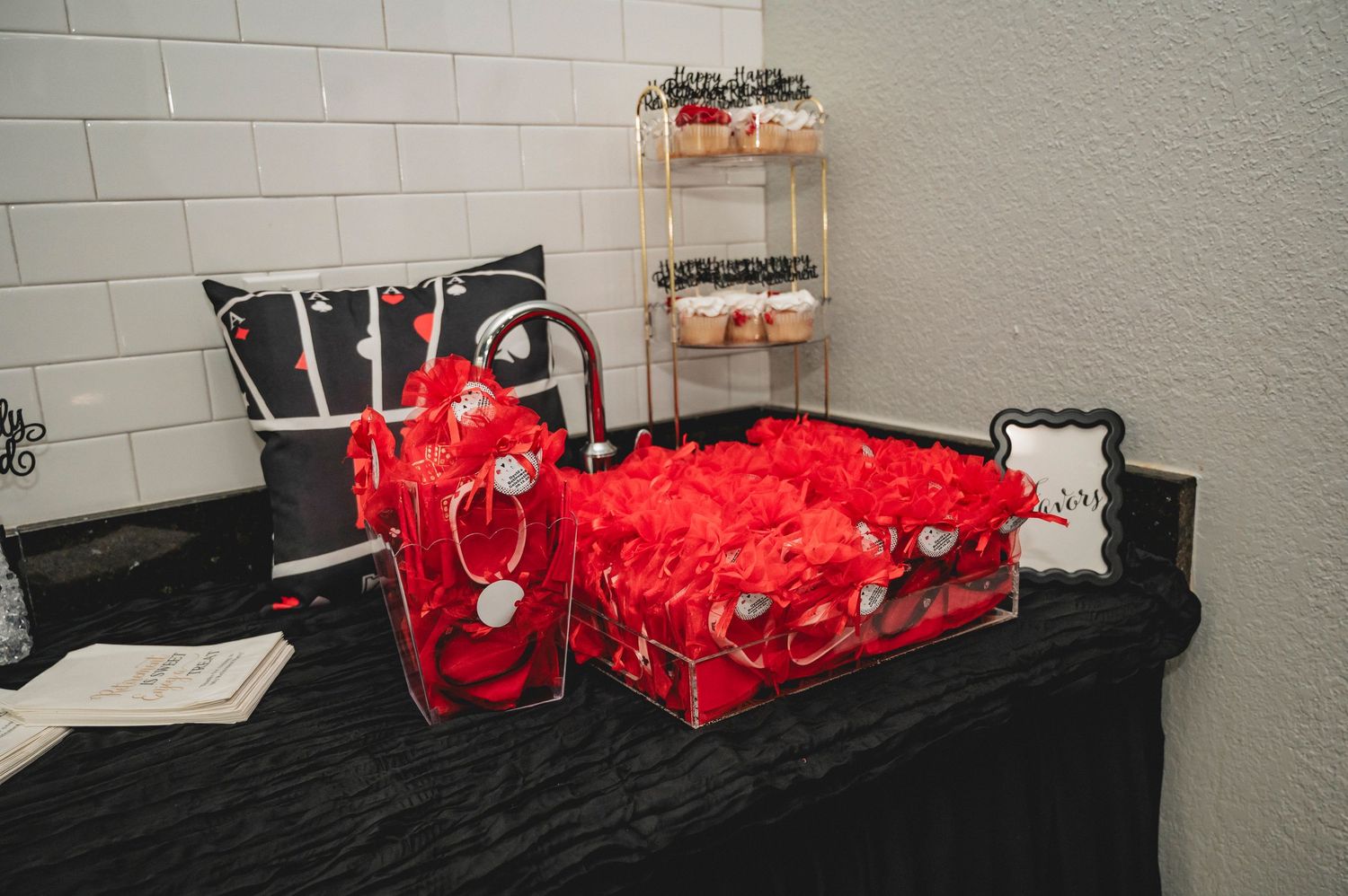 Red tablecloth and decorative items set up for a casino-themed party display.