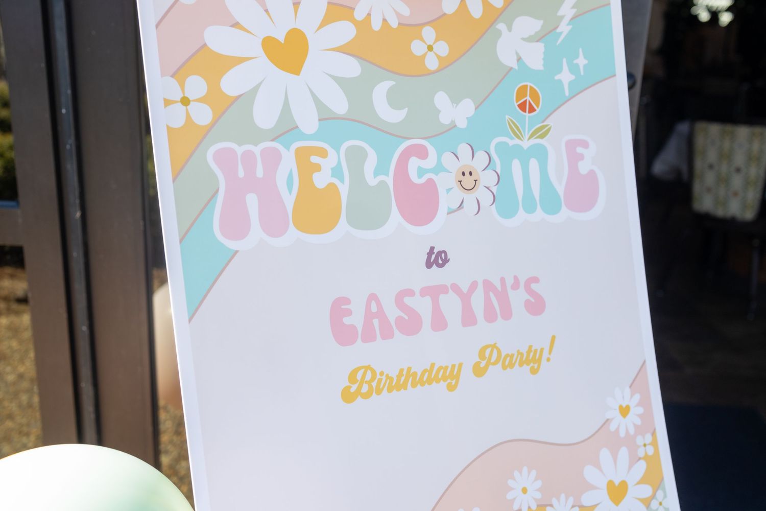 Pastel colored party decorations and hanging banners featuring floral designs and moon motifs create a dreamy celebration setup.