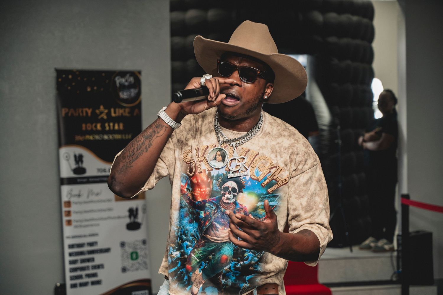 Performer in cowboy hat entertains crowd at casino-themed party with colorful lighting.