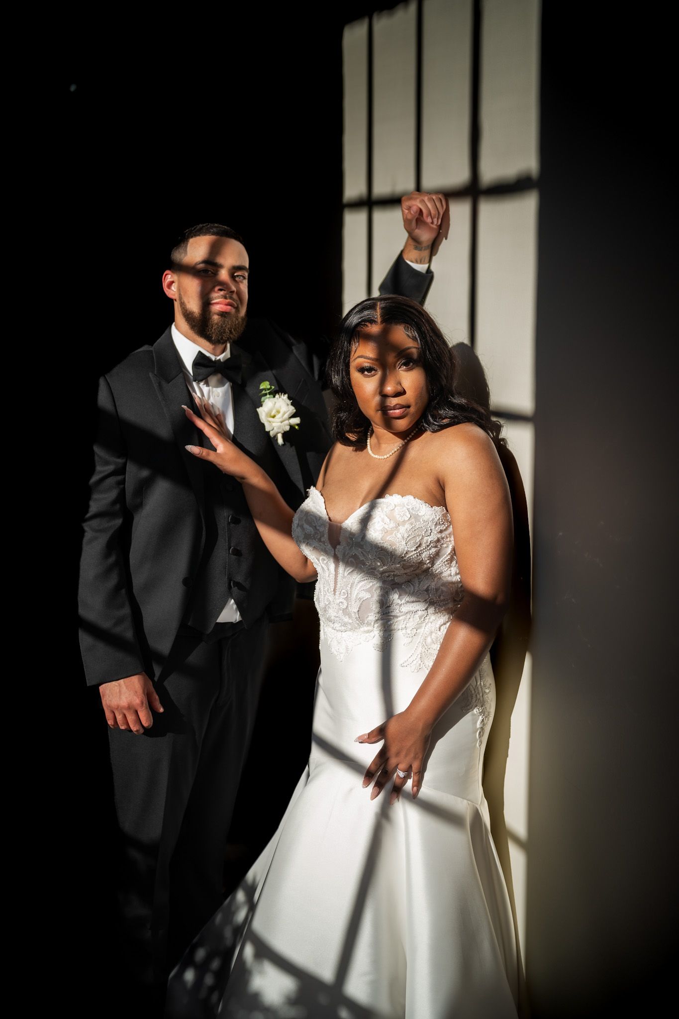 Dramatic black and white wedding portraits showing a bride in a strapless white gown with artistic shadow play.