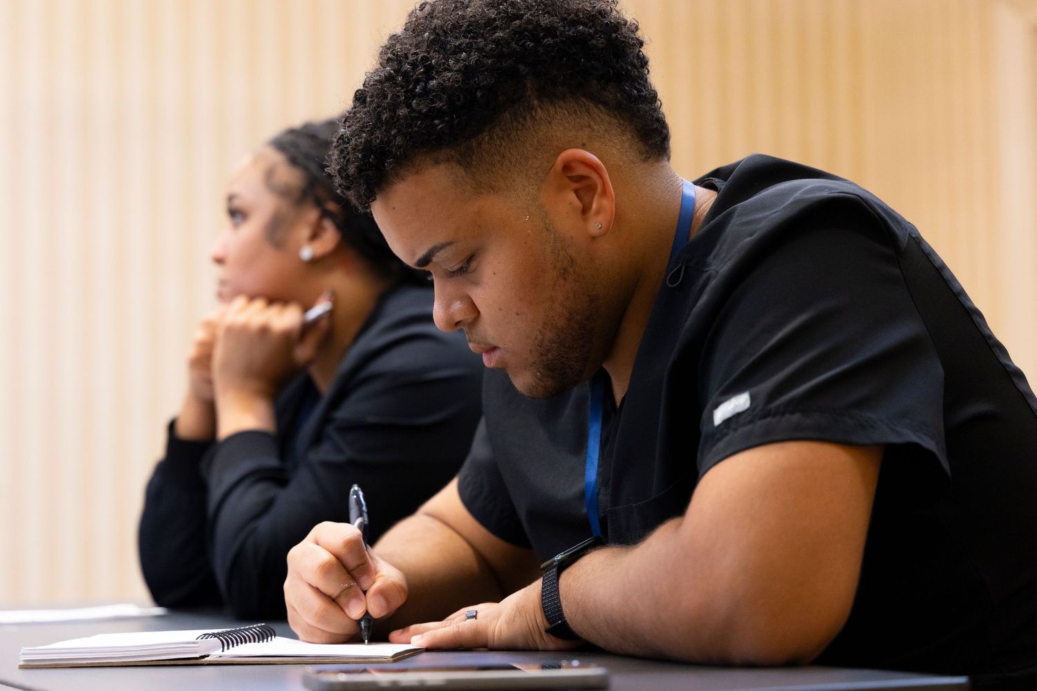 Students rest their heads on desks while appearing to take a nap during class time.