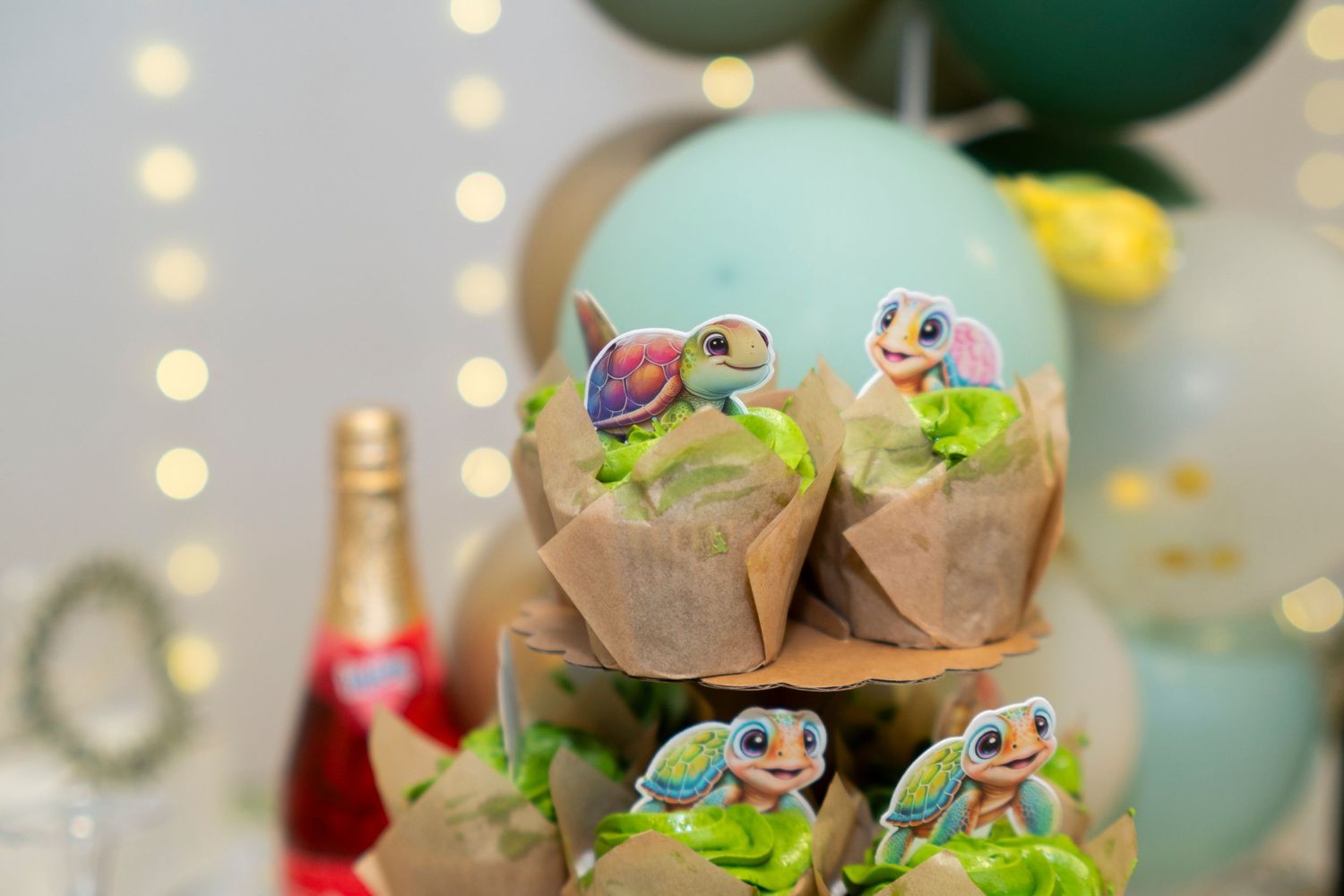 Colorful frosted cupcakes topped with cute frog decorations arranged on a party dessert table with bokeh lights.