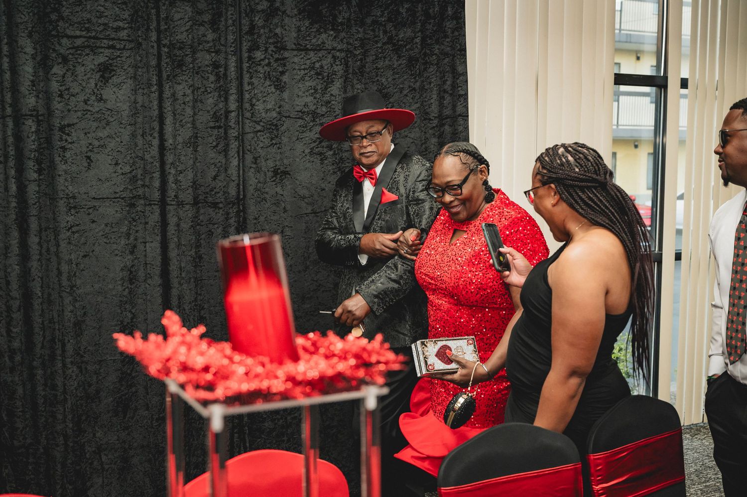 Event space decorated with red and black drapes and party decor for a casino-themed celebration.
