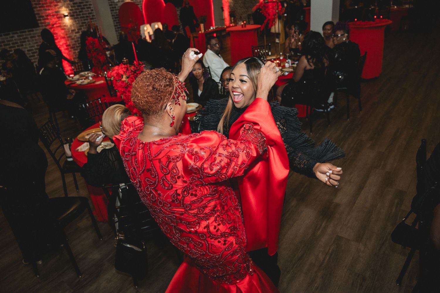Dance floor and seating area illuminated by overhead string lights with red accent lighting.