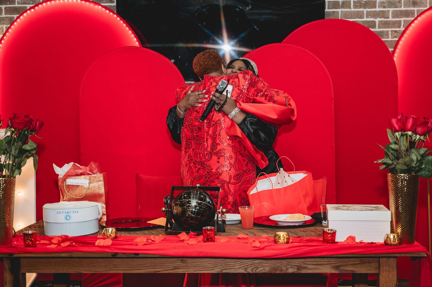 Red tablecloths and decorative elements adorn tables at a festive celebration.