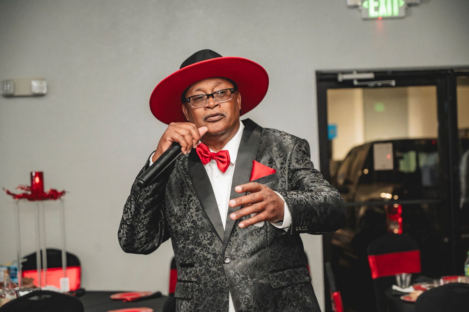 Guests in formal attire and red accessories celebrating at an elegant casino-themed event.
