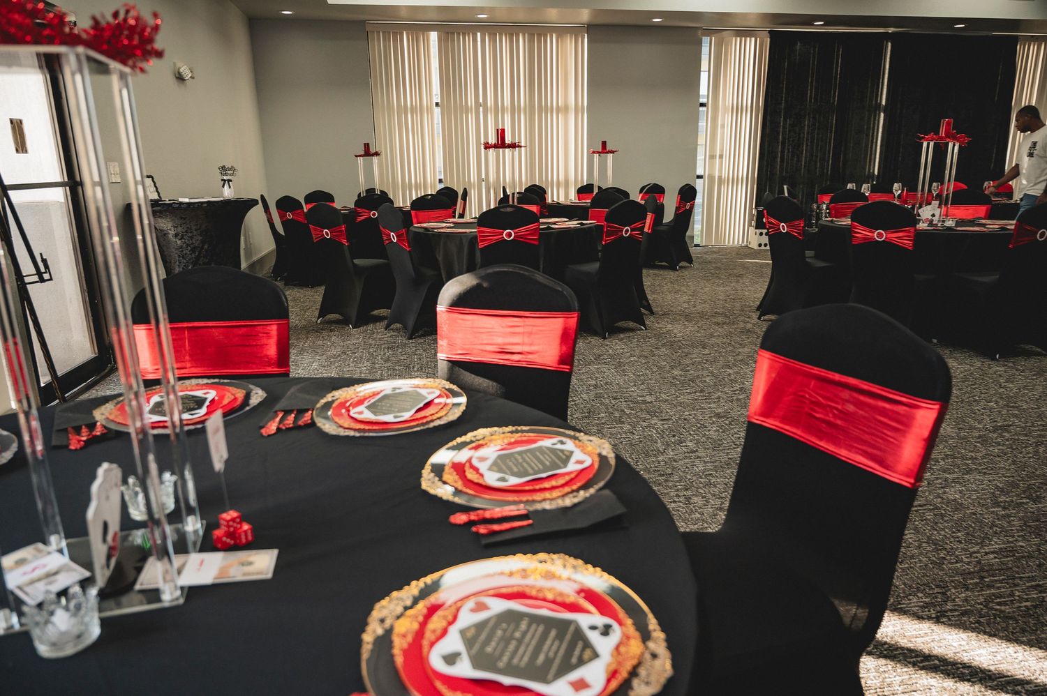 Modern gaming setup with red and black chairs arranged around circular tables in a spacious eSports lounge area.