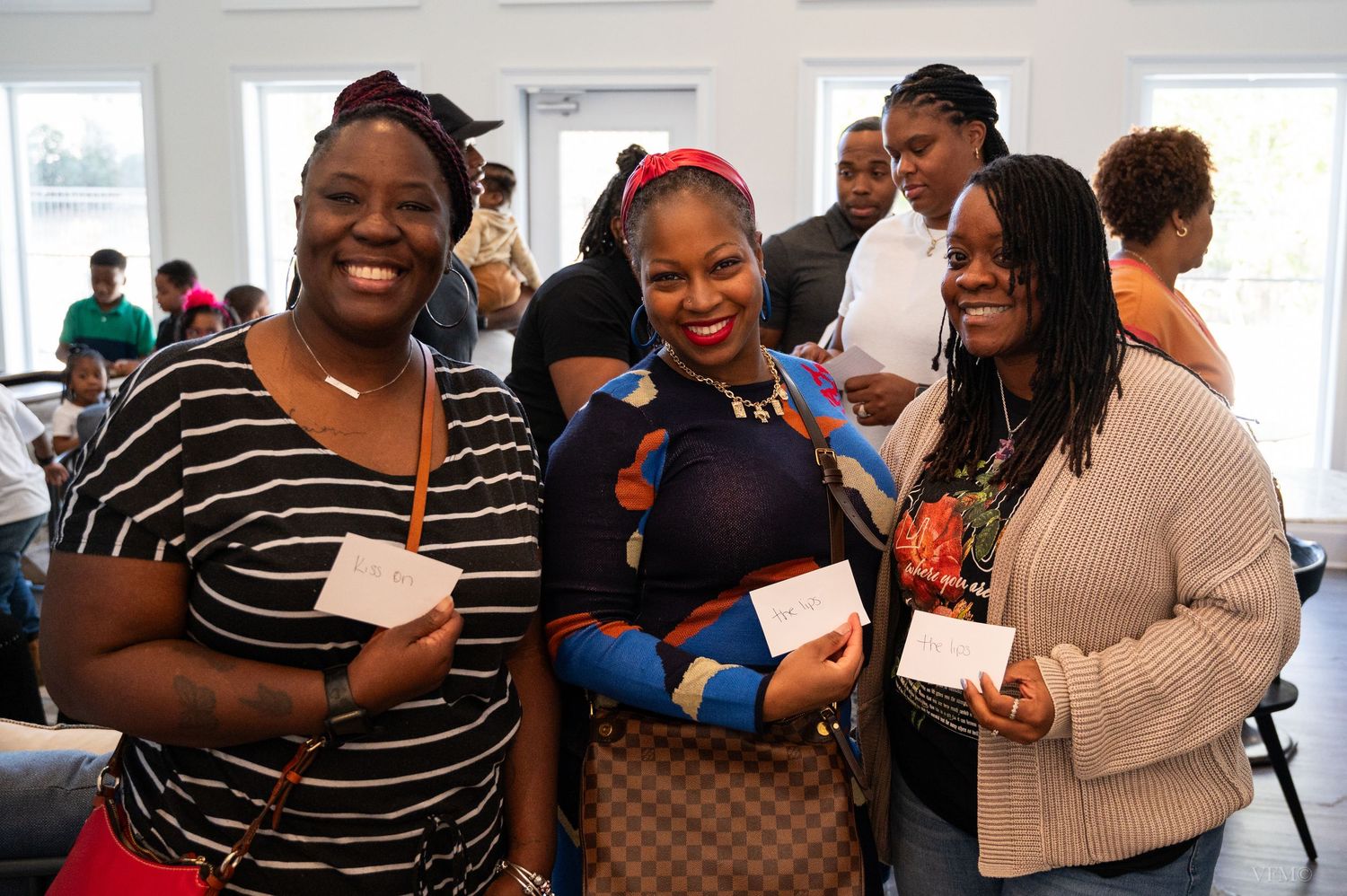 A group of people celebrating at a social event, sharing warm embraces and smiles together.