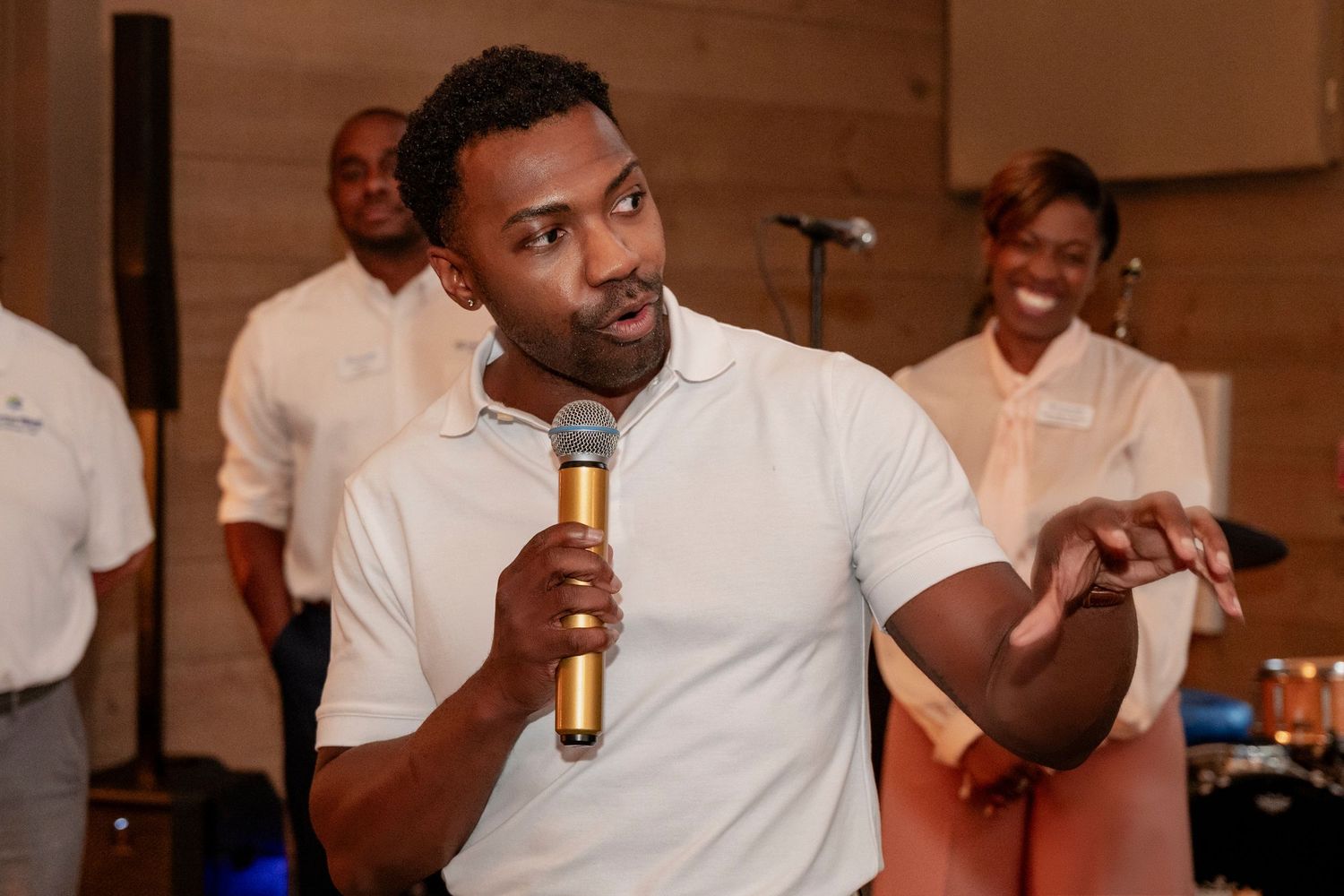 A group of people in white shirts gather at what appears to be a social event or party setting.