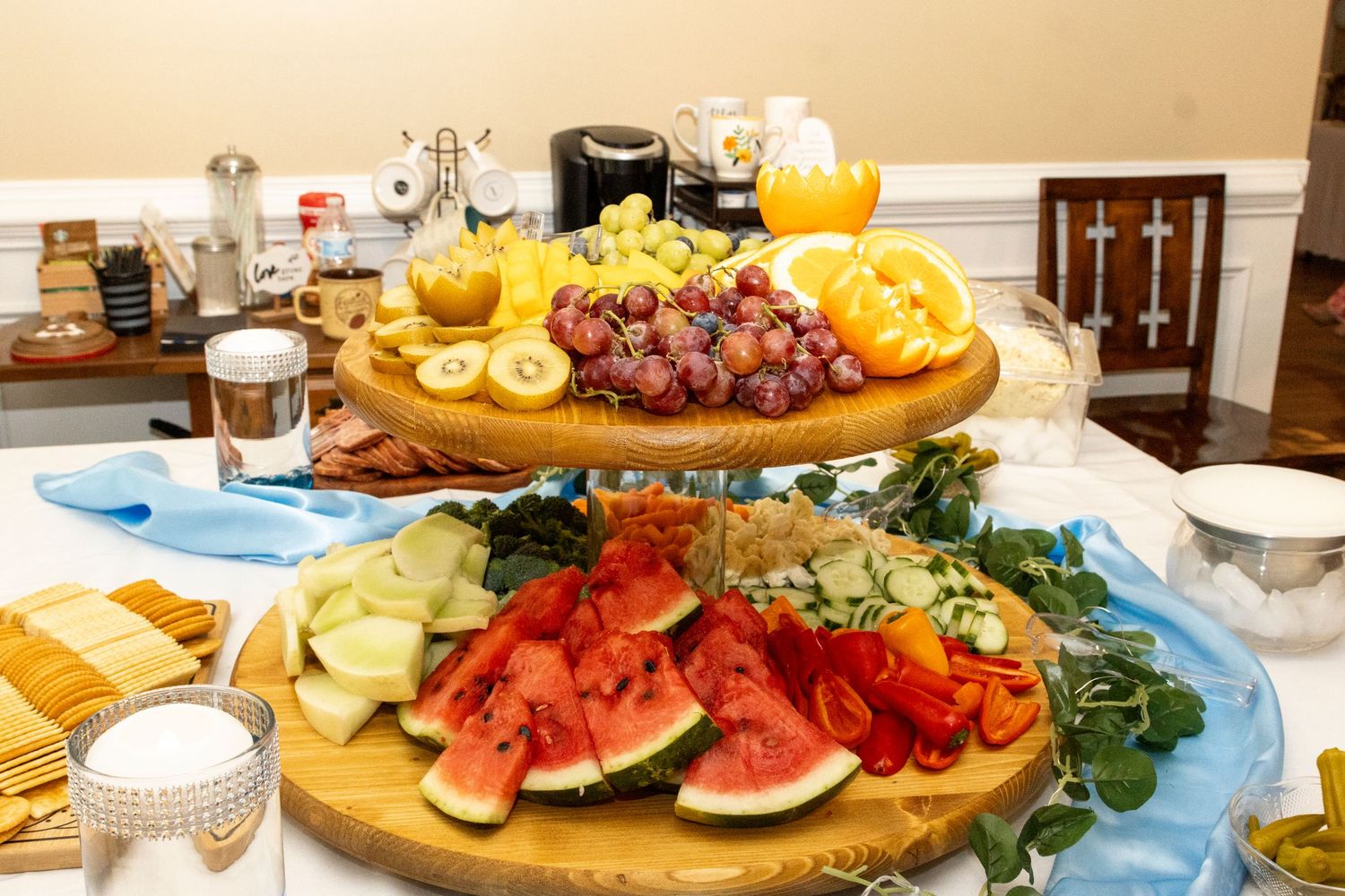 A beautiful brunch spread on a table with pastries, fruits, and charcuterie displayed on tiered serving platters.