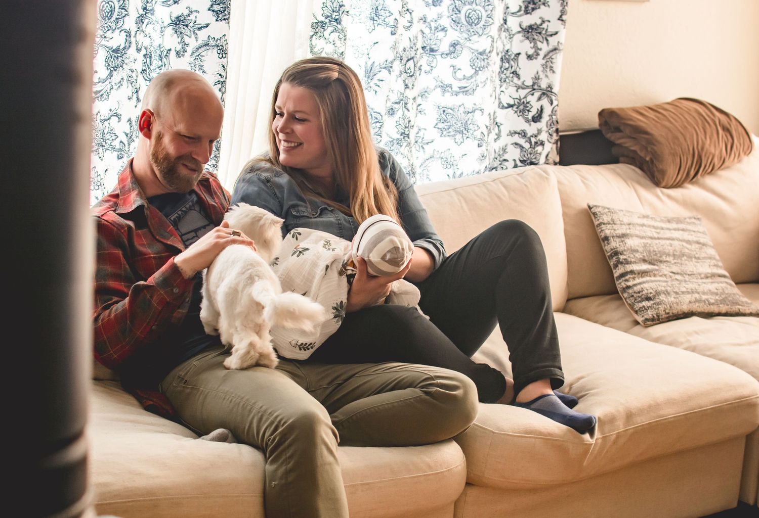 Cozy indoor lifestyle photoshoot with cat and couple relaxing on white couch during a newborn session in Tacoma, WA