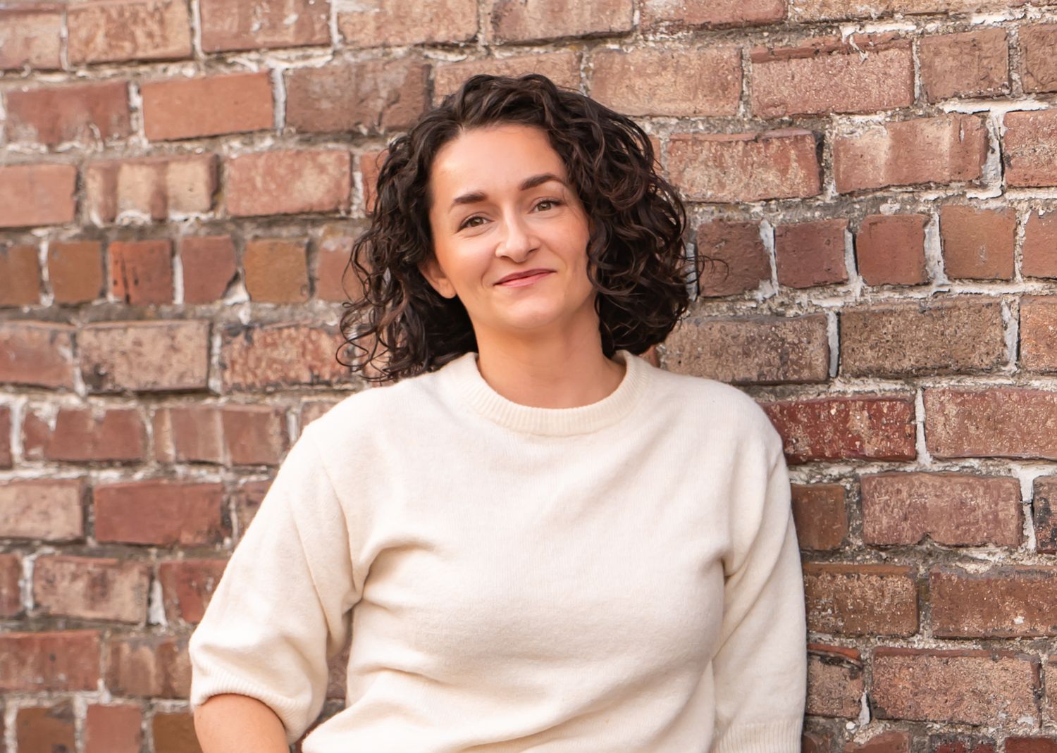 Portrait session against rustic brick wall background in natural lighting in Enumclaw, WA