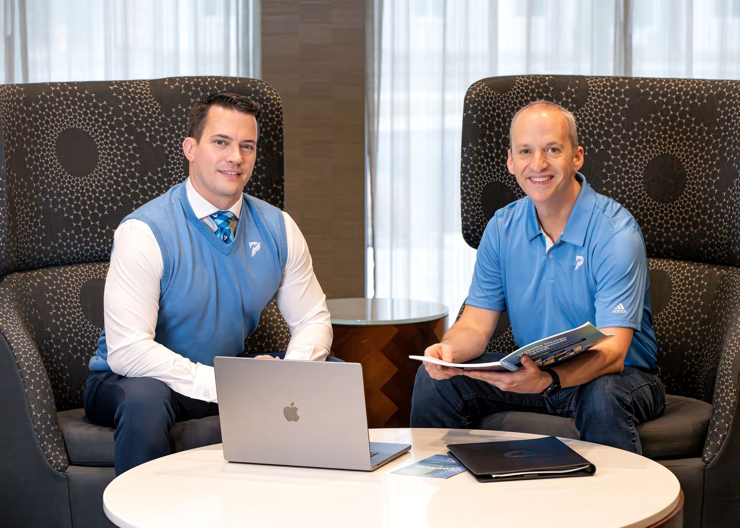 Professional working session at round table with laptop and business materials. Two men pose for a corporate branding session in Pullman, WA