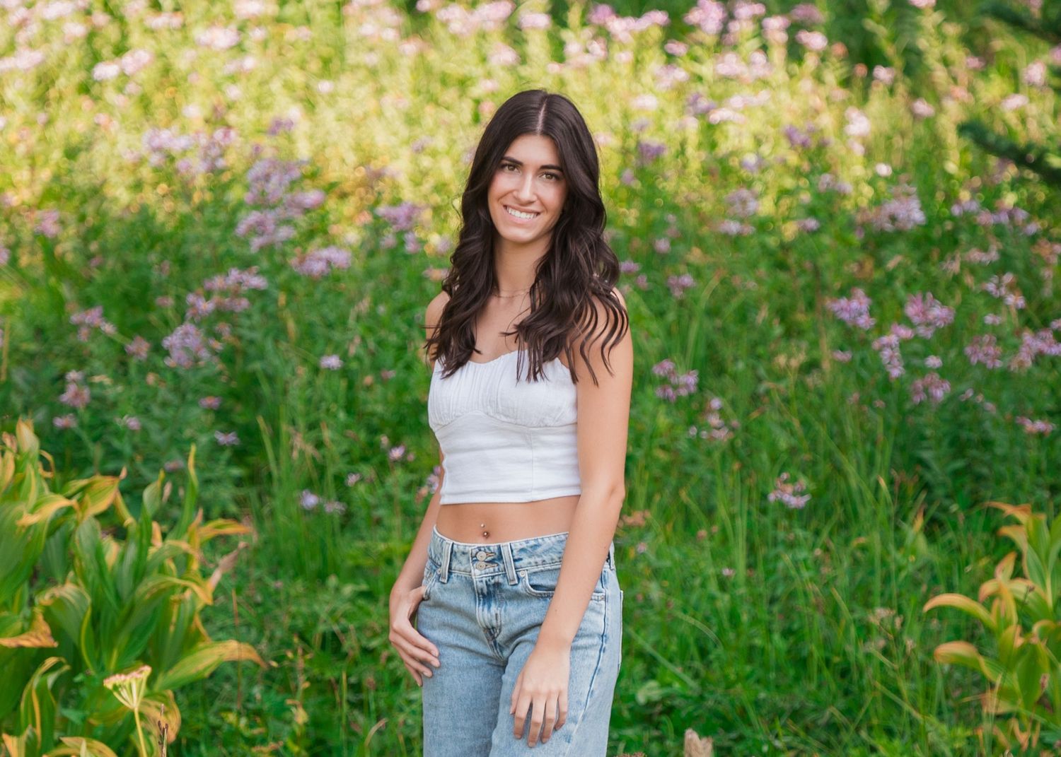 Summer senior portrait session among vibrant wildflowers and tall grass on Mount Rainier